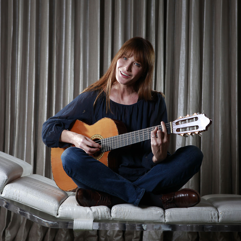 Singer-songwriter Carla Bruni-Sarkozy sings as she poses for a portrait to promote her new album "Little French Songs" in New York, in this June 25, 2013 file photo. Beaming from billboards, glossy magazines and onstage, singer-songwriter and former supermodel Carla Bruni-Sarkozy has unapologetically embraced her post-first lady life in a public way, resuming her personal career while lending sizzle to the mystique of former French President Nicolas Sarkozy. REUTERS/Carlo Allegri/Files (UNITED STATES - Tags: ENTERTAINMENT PROFILE PORTRAIT)